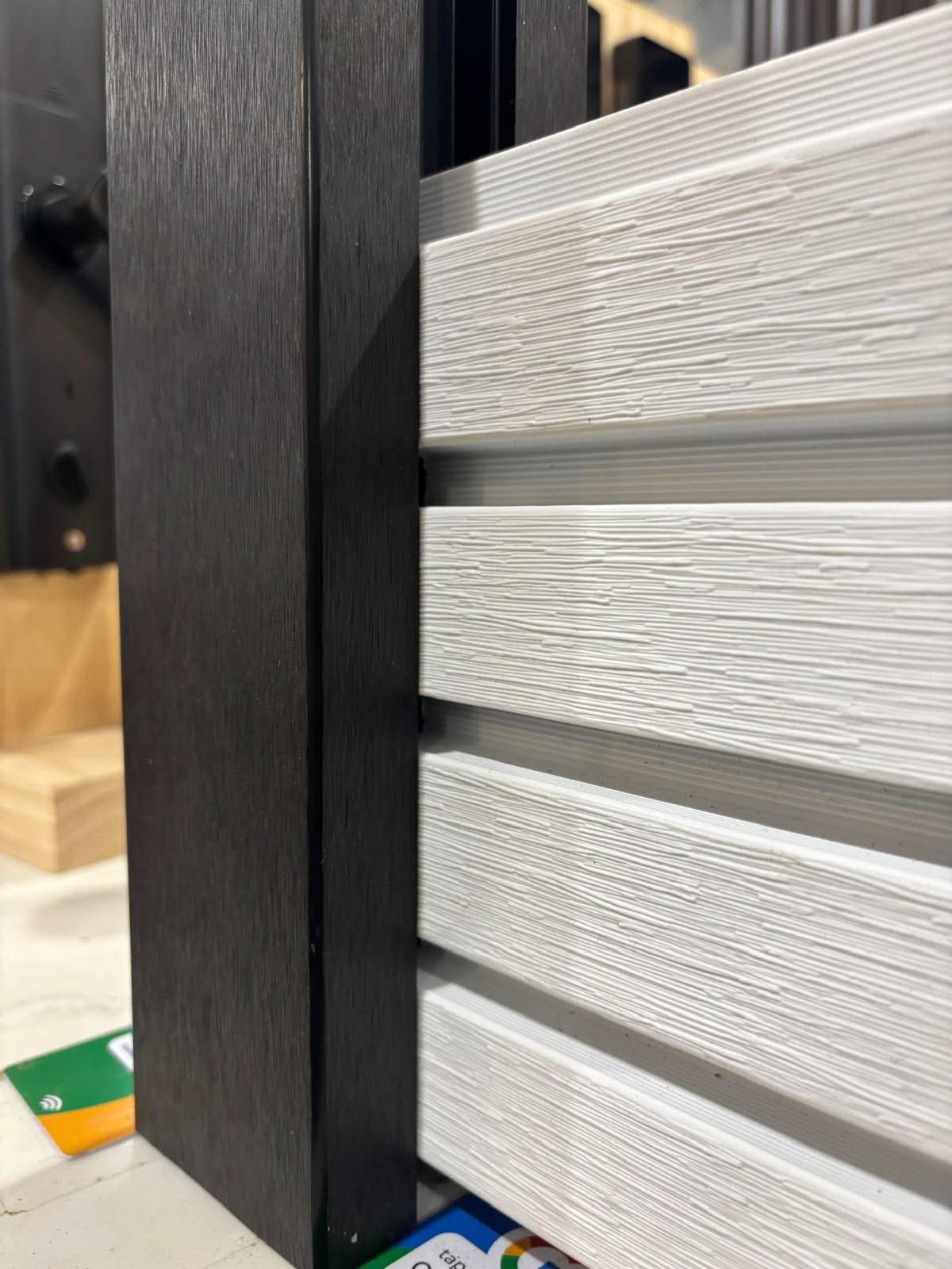Horizontal WPC cladding post and accessories by Cladding Supplies Australia, showing textured wood-look panels and mounting hardware.