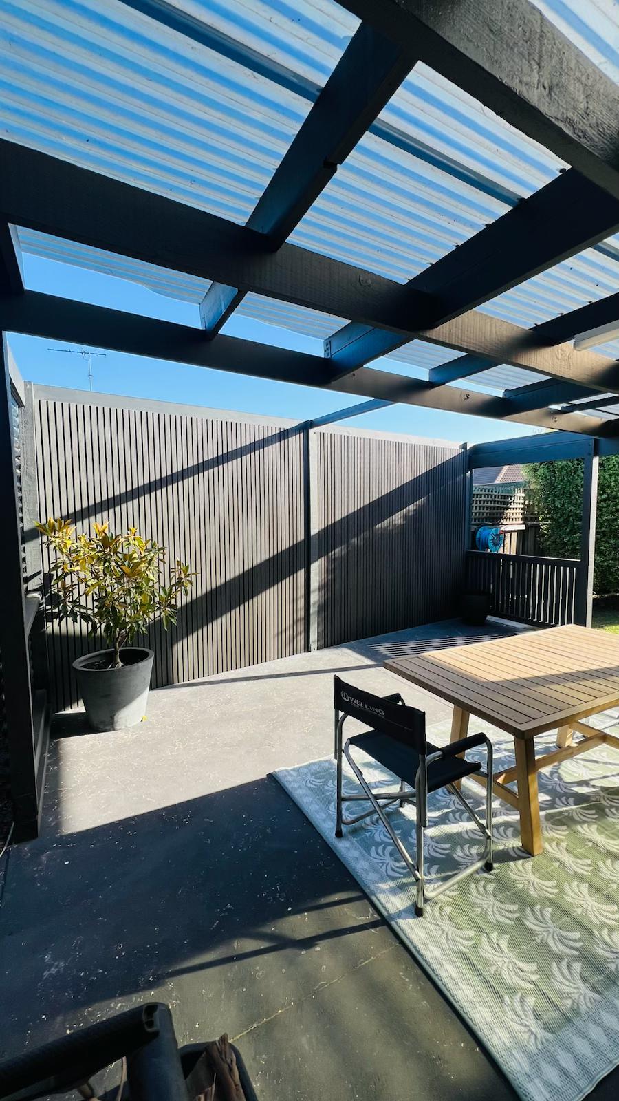 External half cladding in charcoal grey with four slats, by Cladding Supplies of Australia, showing textured wooden panel design.